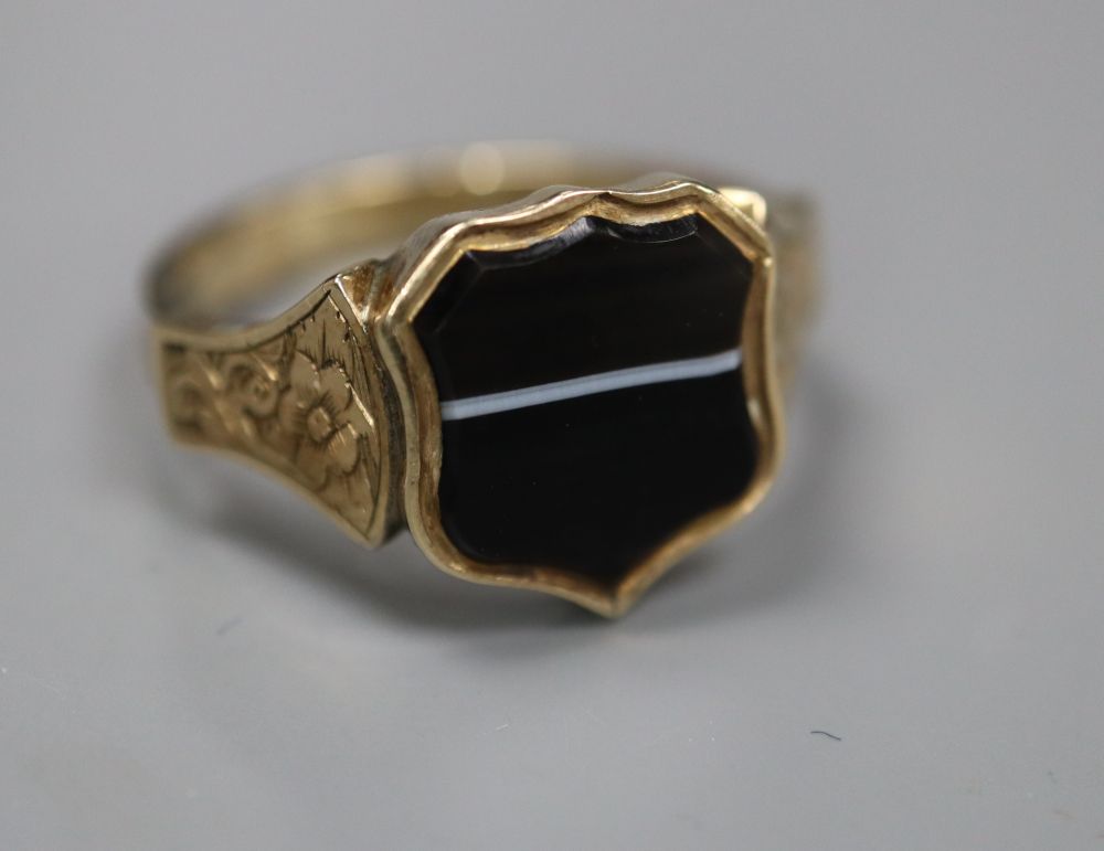 A late Victorian yellow metal and shield shaped banded agate set signet ring, size P/Q, gross 3.4 grams.